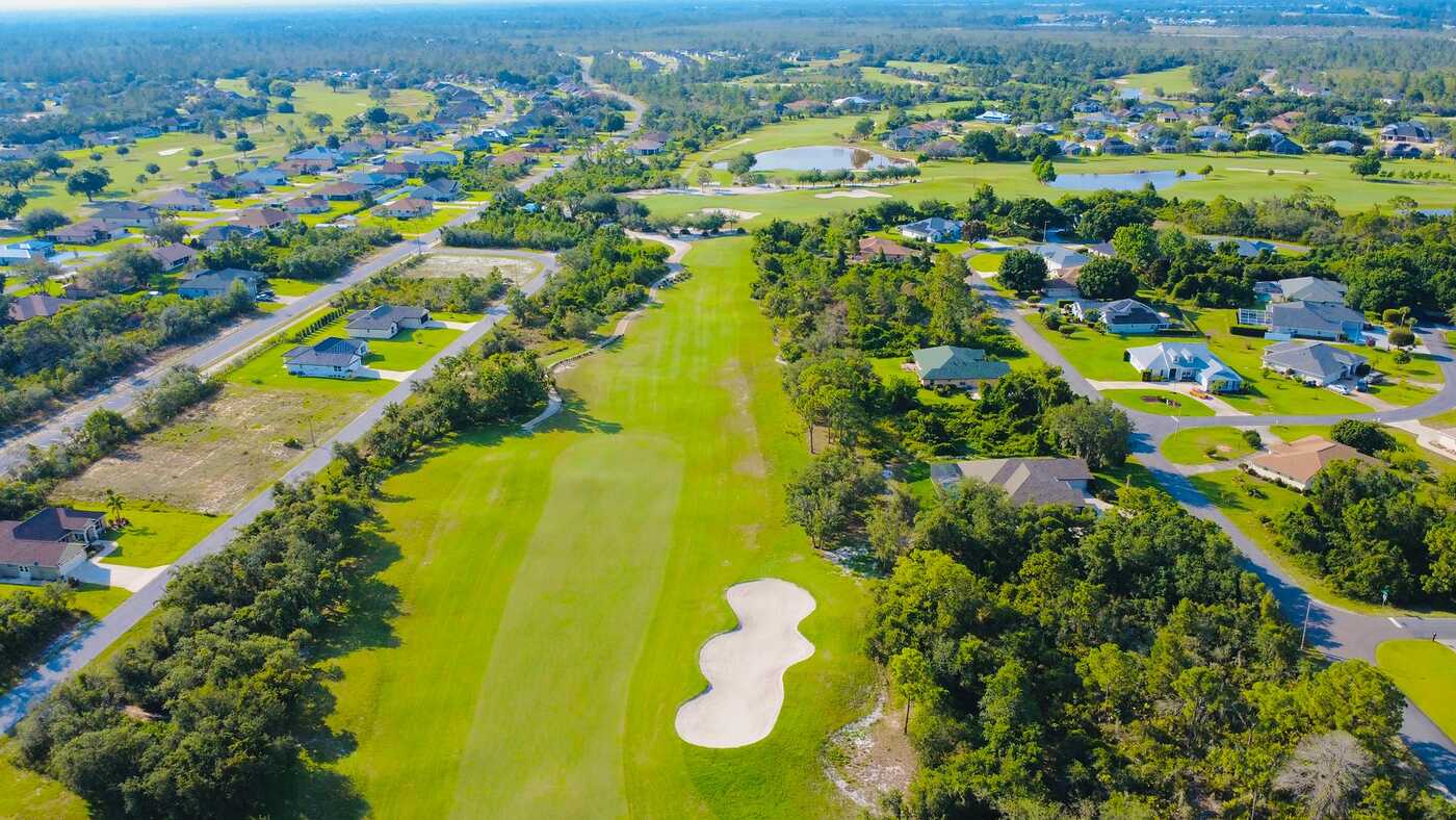 An aerial view of a golf course surrounded by homes