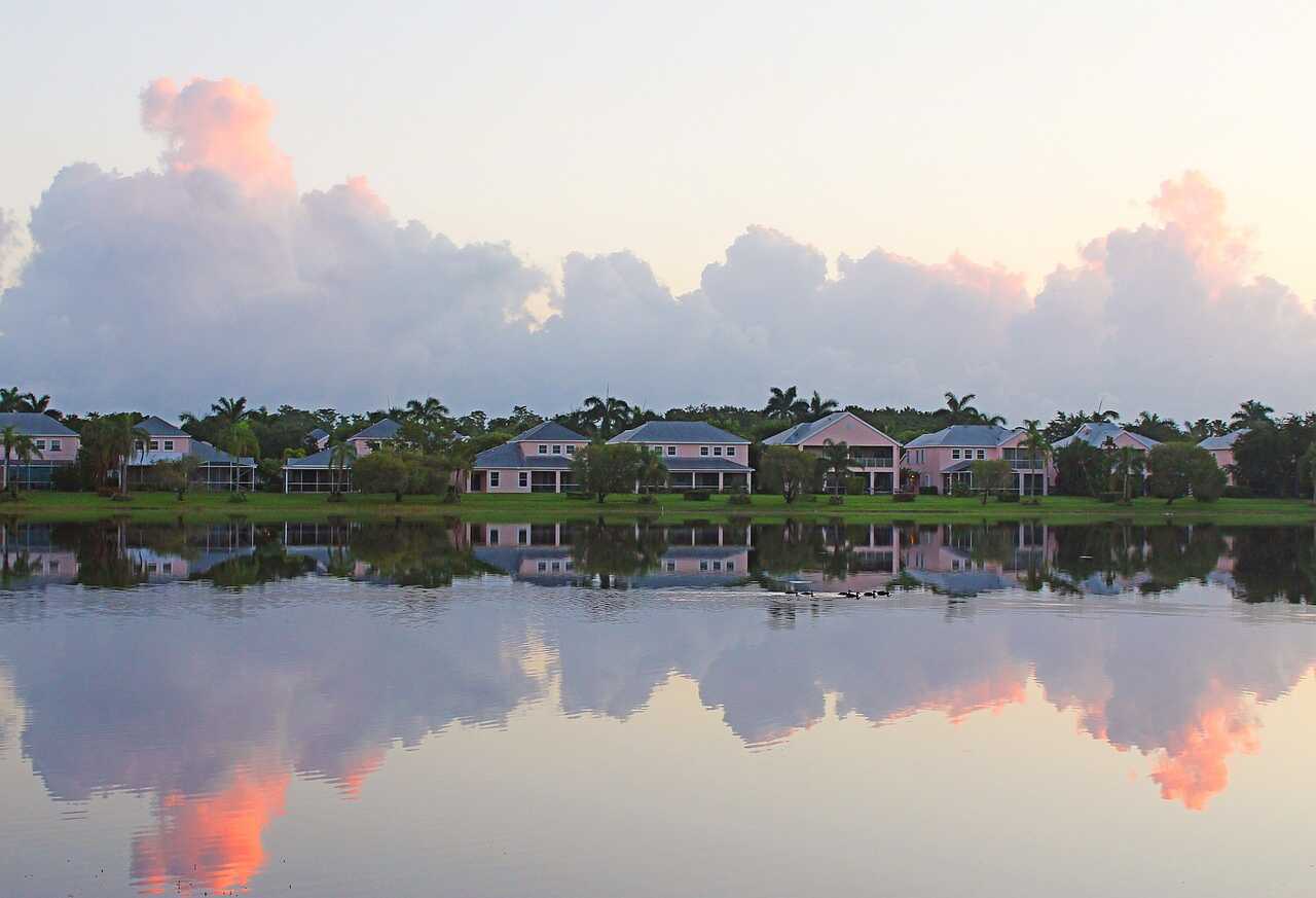Houses reflected in a subdivision lake at dusk